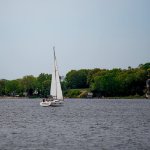 A sailboat drifts across Muskegon Lake